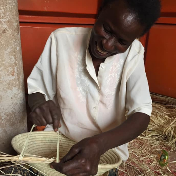 Image of a Ugandan woman crafting an Afribeads basket